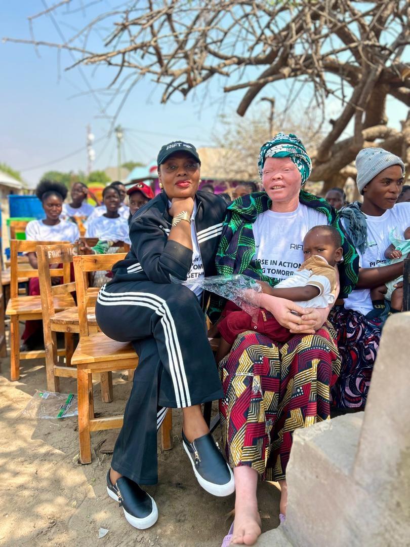 Vivian Sirikwa seated beside a programme participant holding her child at the launch